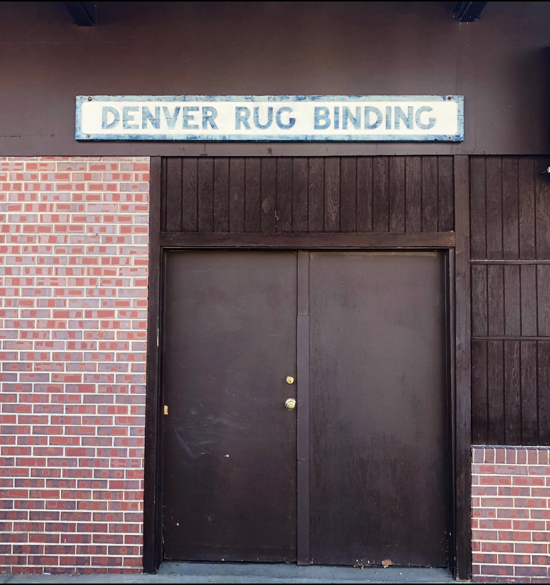 Denver Rug Binding shop sign at the Sheridan workshop entrance.